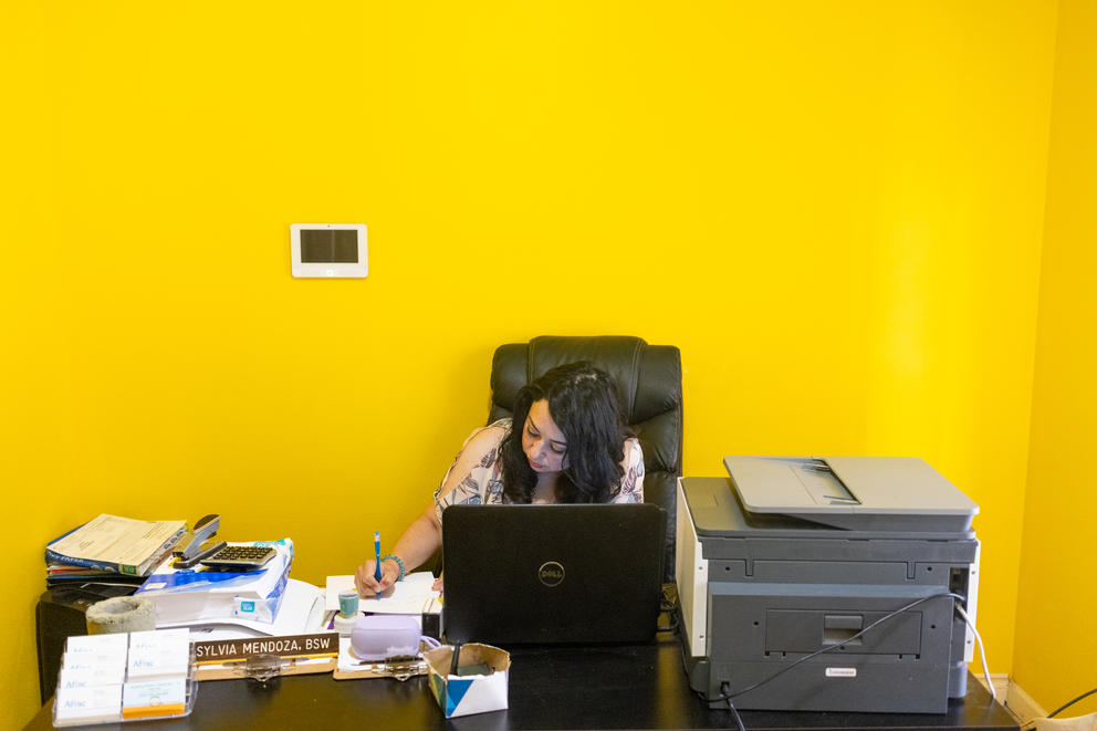 Silvia Zarate writes notes in her home office