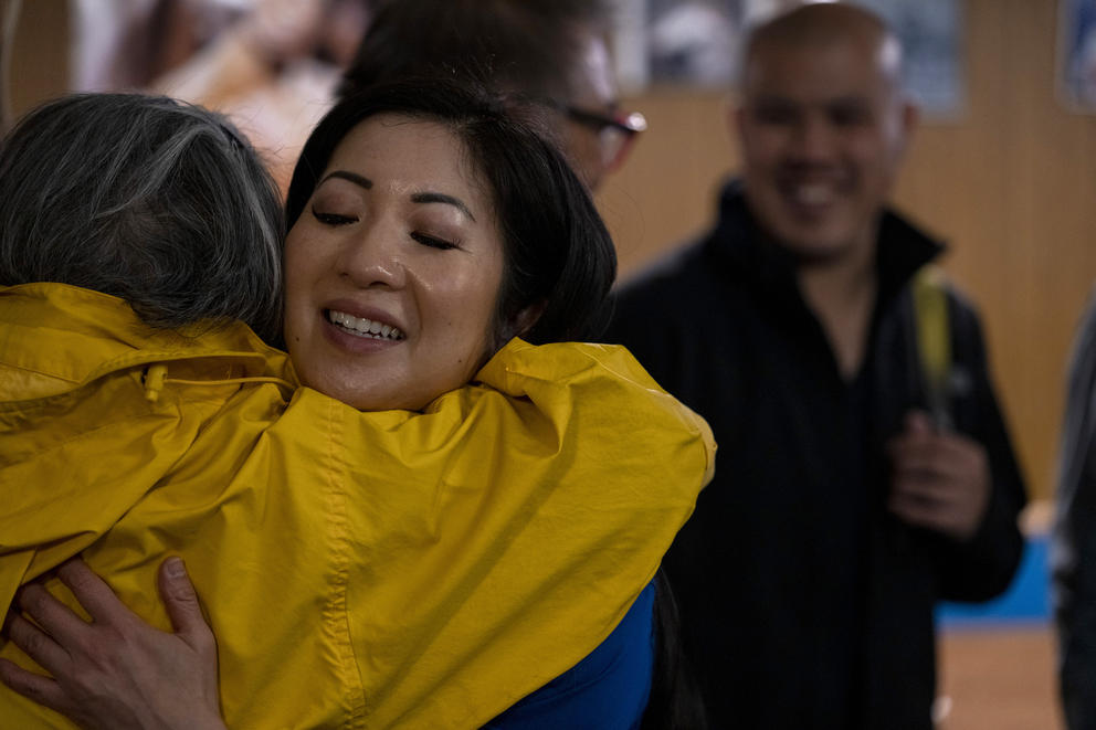 a woman hugs another person