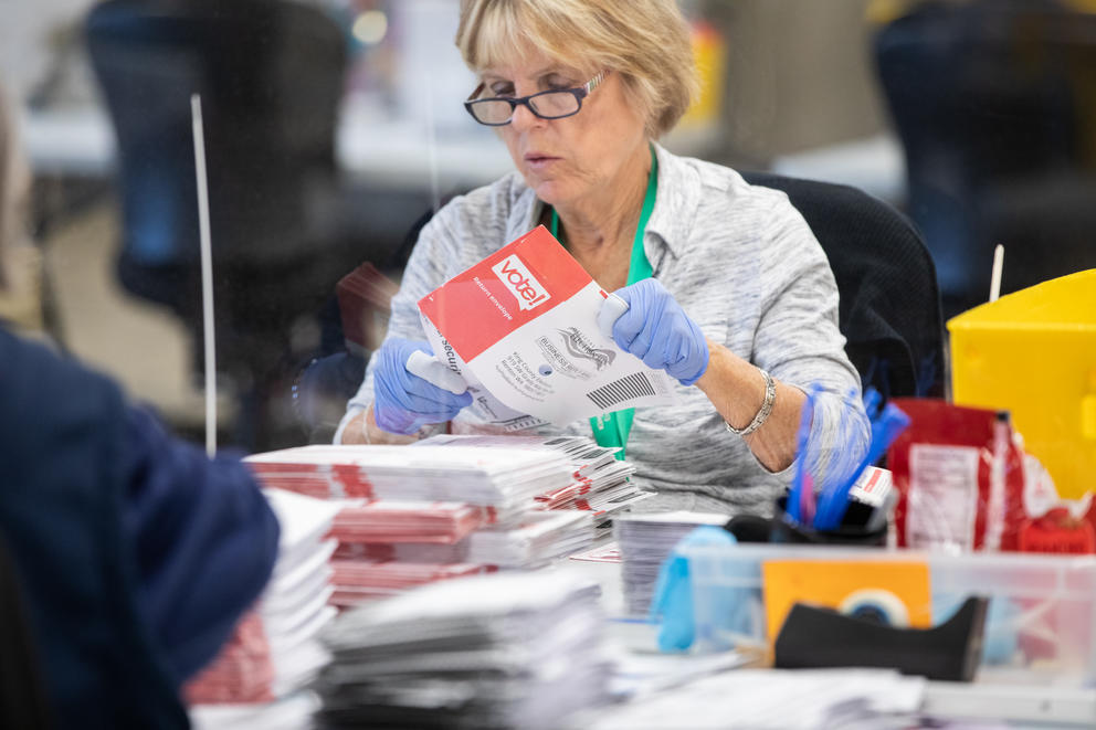 election worker opening ballot envelopes