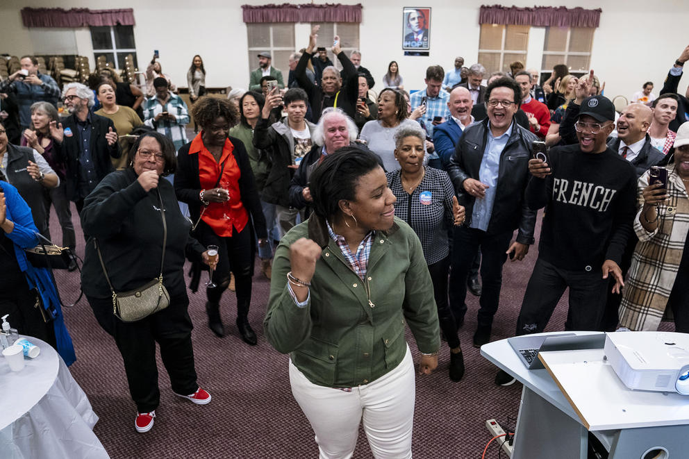 a woman pumps her fist in a crowd of people