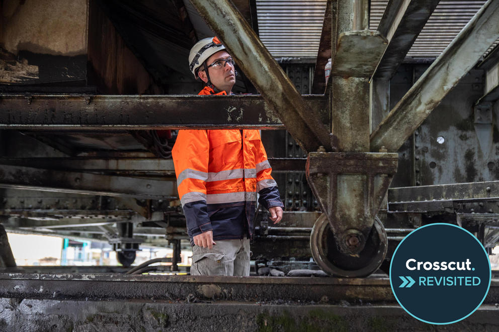 A worker examines the underside of a bridge.