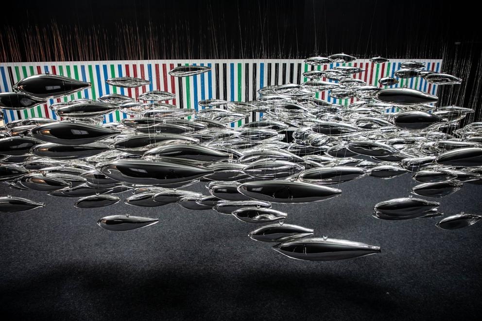 photo of a collection of suspended glass forms in the shape of fish