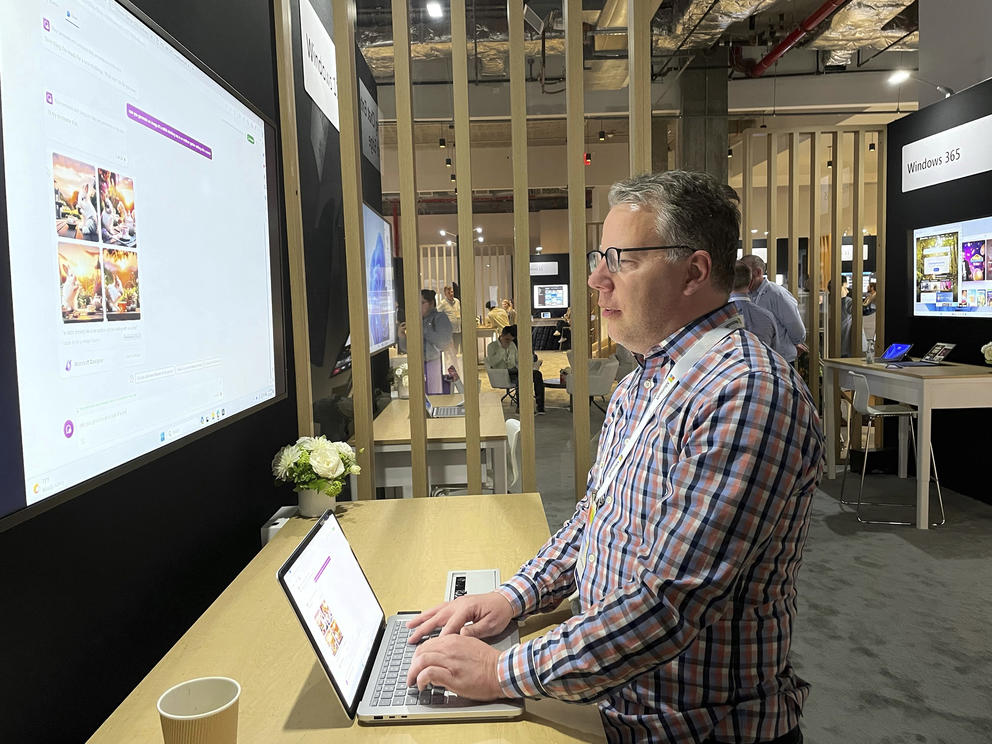 man sitting at a computer showing a new artificial intelligence tool for generating images