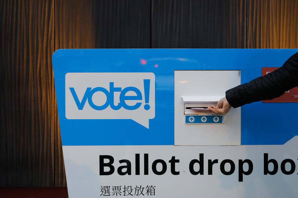 Voters drop off ballots at the White Center Library ballot box