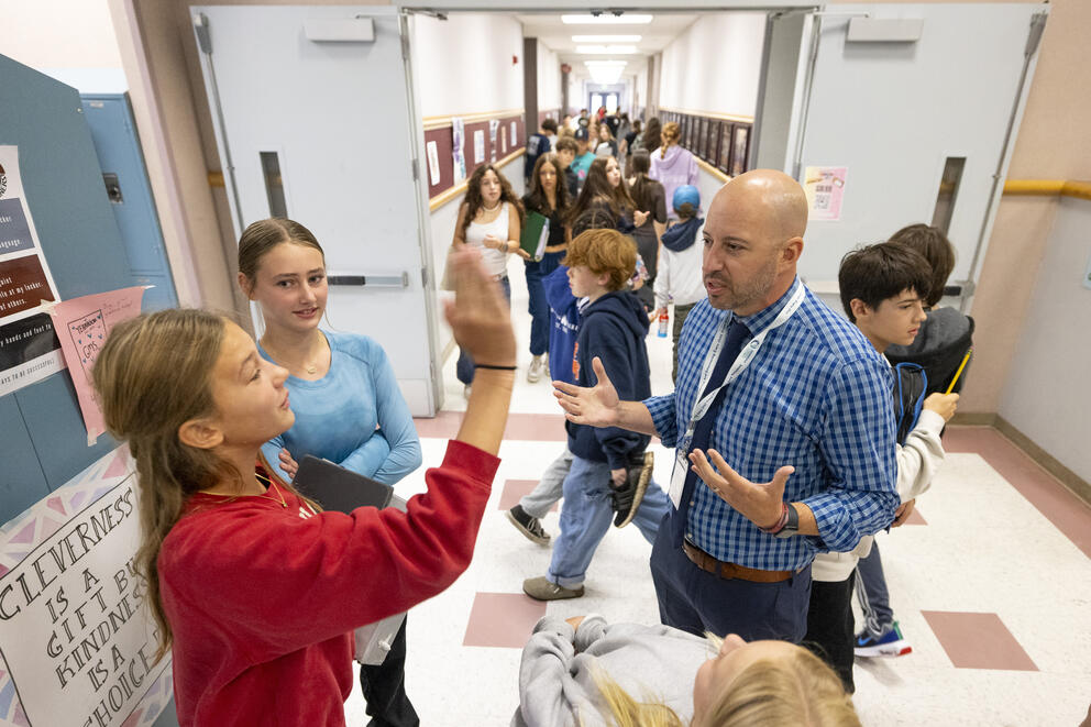 Principal Ty Robuck speaks to students in the hallway at Goodman Middle School