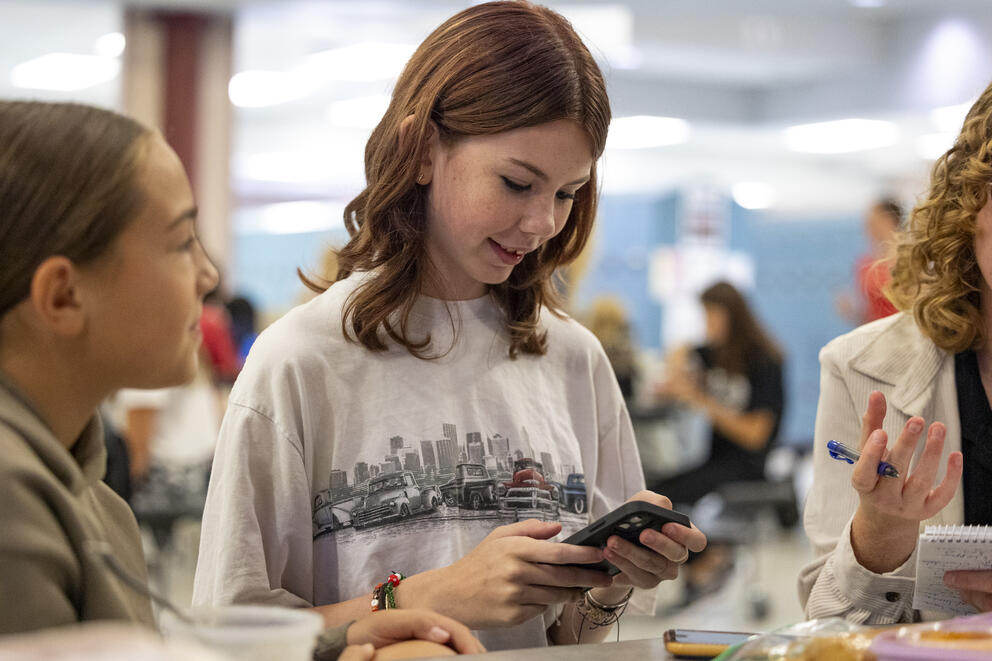 Students use a smart phone during their lunch break.