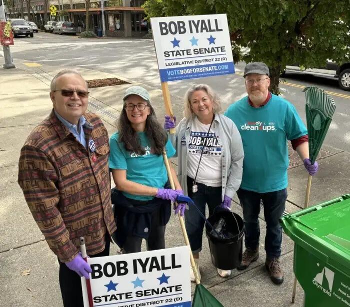 Four people pose for a photo outside, holding campaign signs that say "Bob Iyall State Senate Legislative District 22."