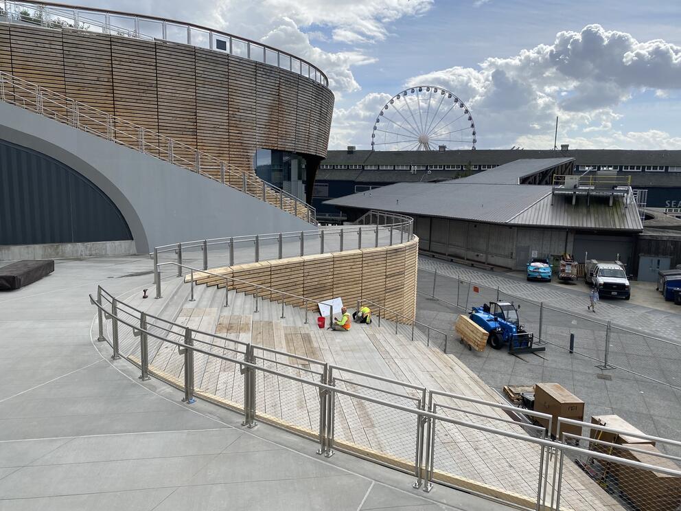 photo of a swooping concrete sidewalk and amphitheater with construction workers in progress
