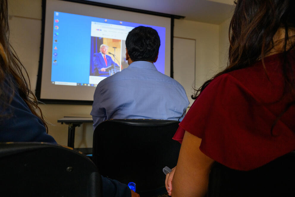 person sitting in front of a tv screen while demostrating the ring