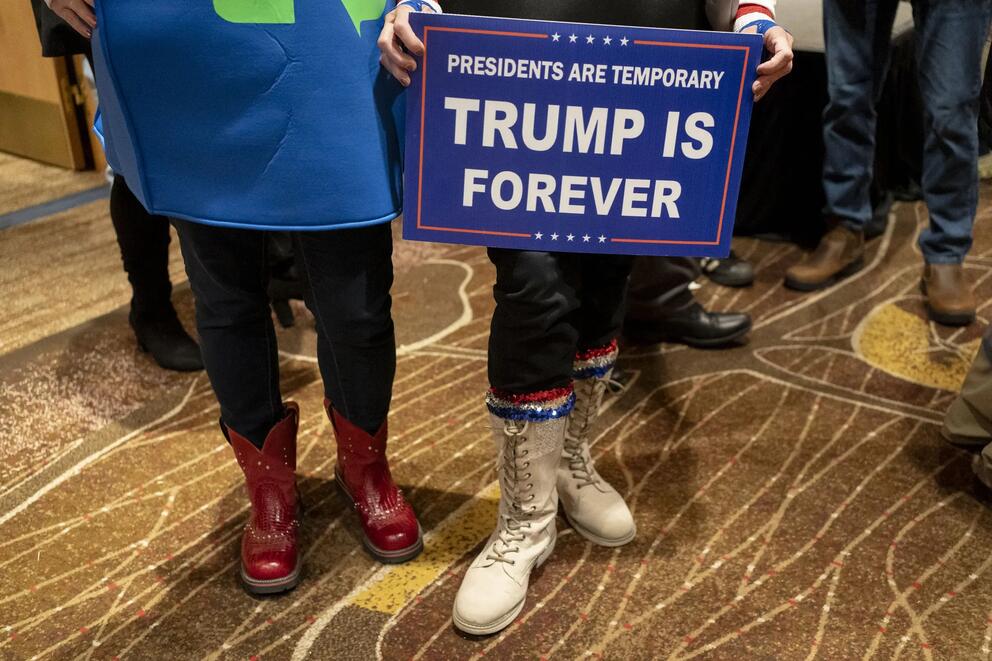 Person holds "Presidents are temporary Trump is forever" sign