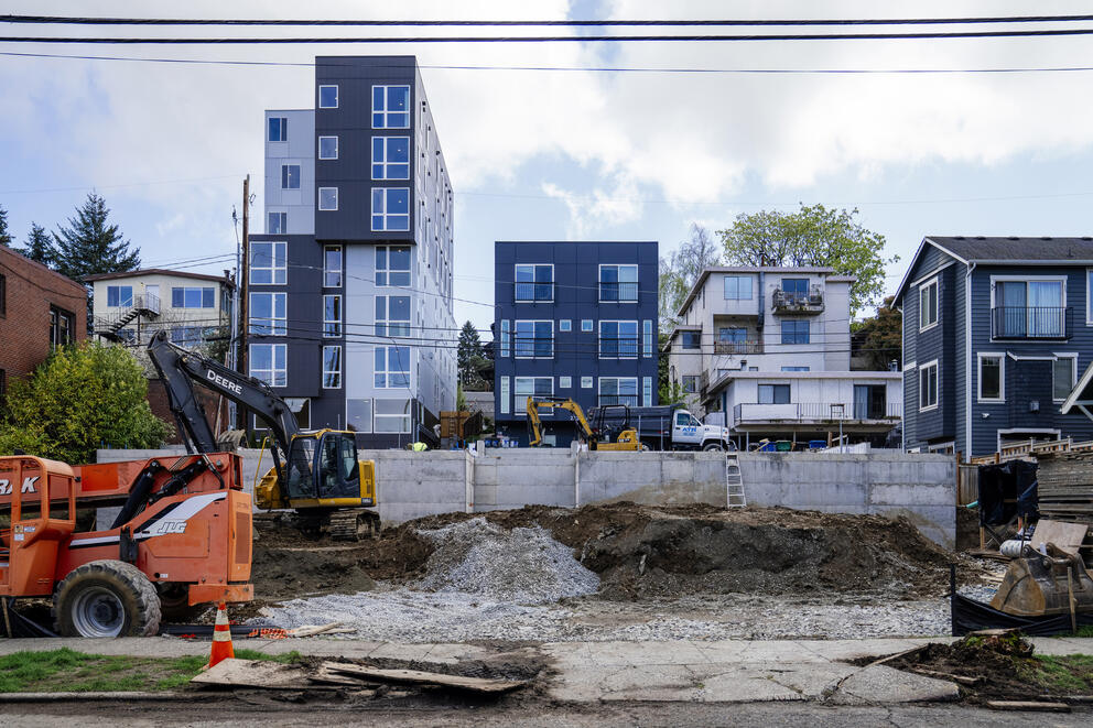 a construction sight with a mix of single family houses and apartments in the background