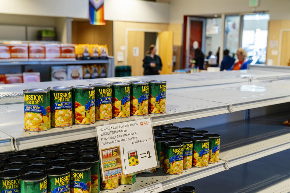 cans of fruit on a mostly barren shelf at the ballard food bank