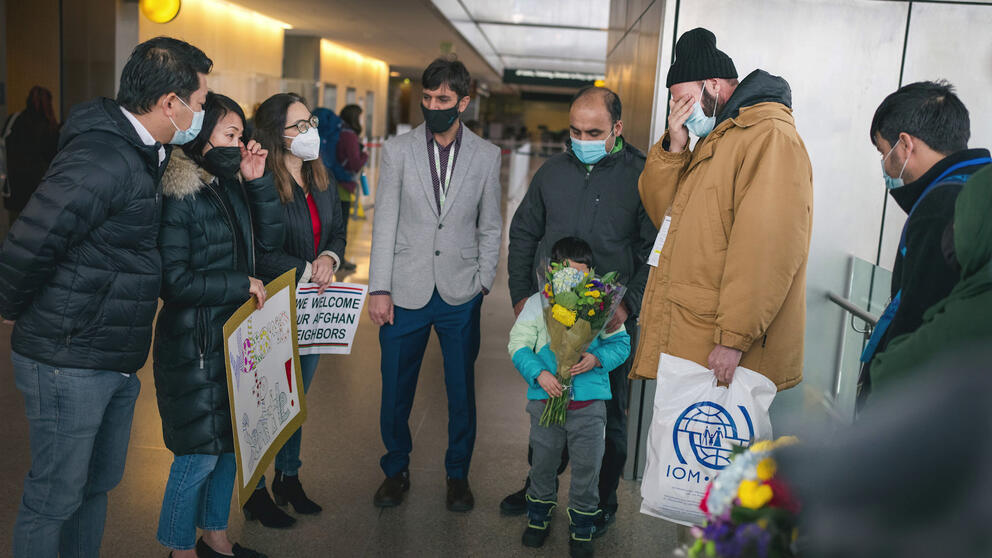 Adults and children in an airport hallway in the early 2020s.