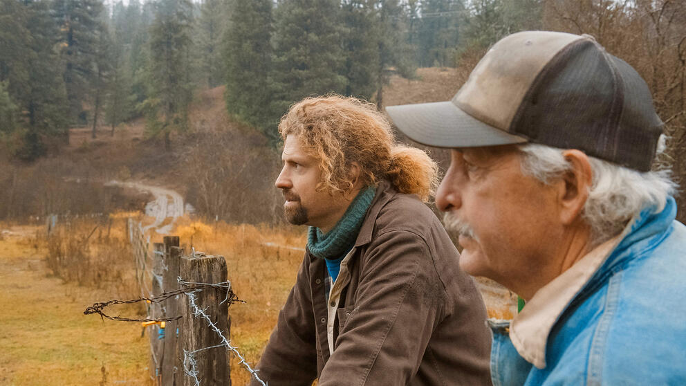 Daniel Curry and Jerry Francis look over a wire fence