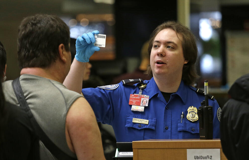 A person in a uniform looks at an identification card.