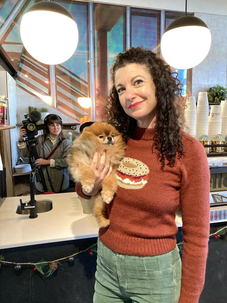 Rachel Belle holding a small, fluffy dog