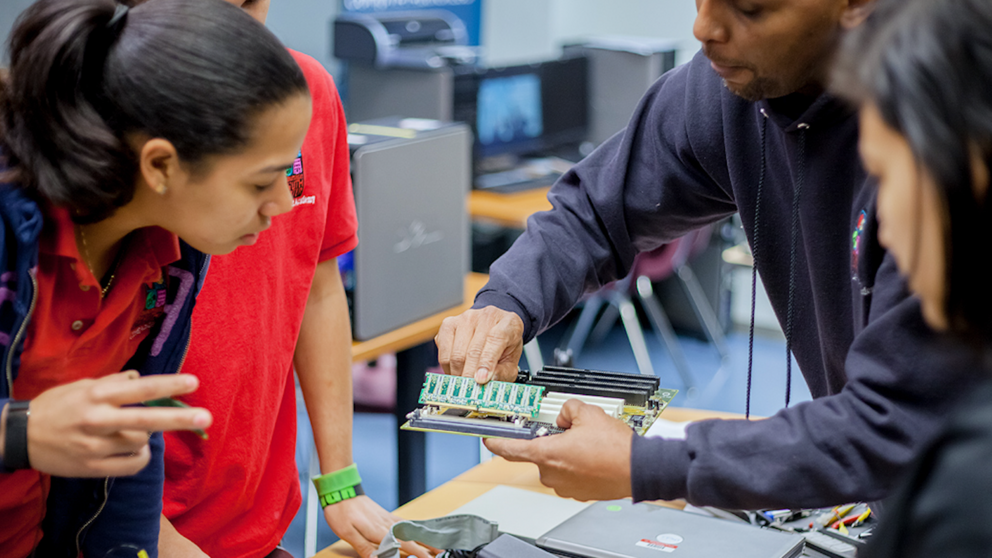 Students gather around a piece of technology