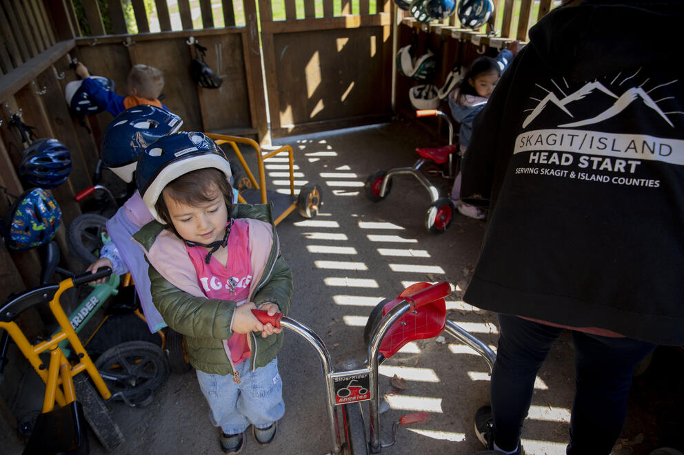 A child prepares to ride a bike.
