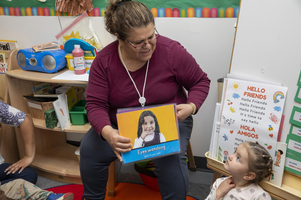 A teacher reads to a group of children.