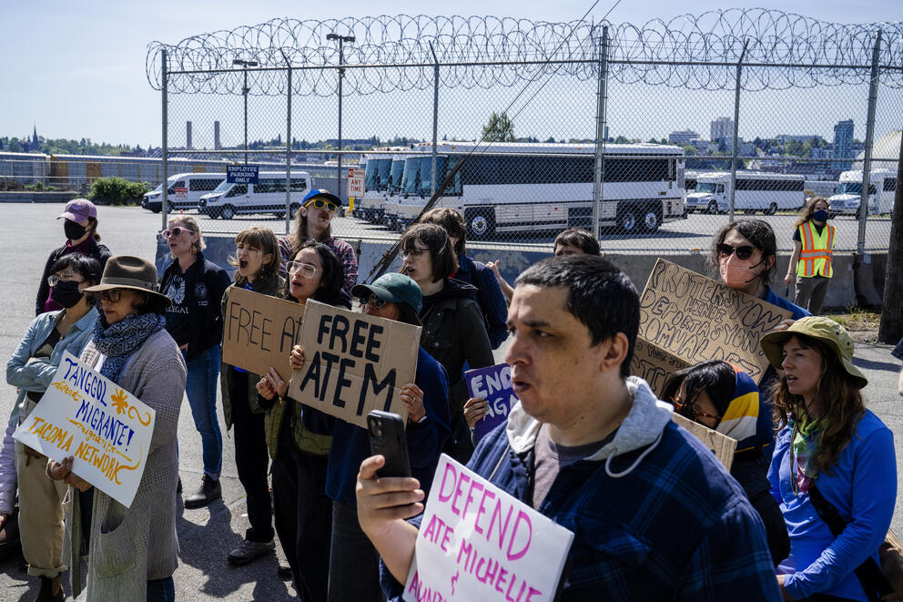 Demonstrators stand outside the Tacoma detention center