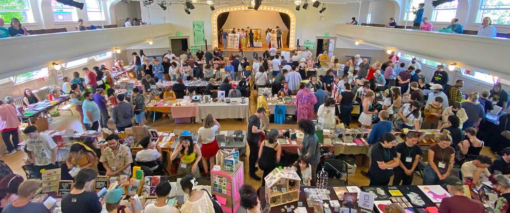 image of a hall filled with desks, displays and people