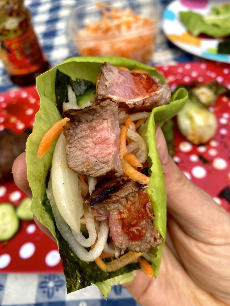 A person holds a wrap with large pieces of streak in it