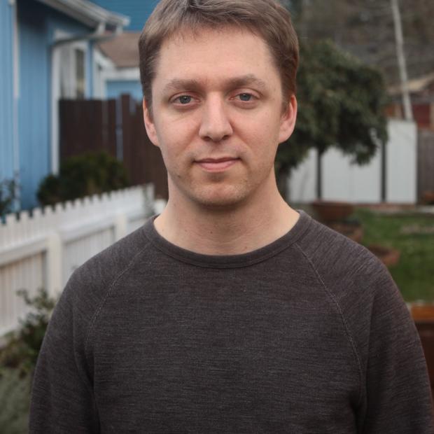 Portrait of a man standing in front of a blue building