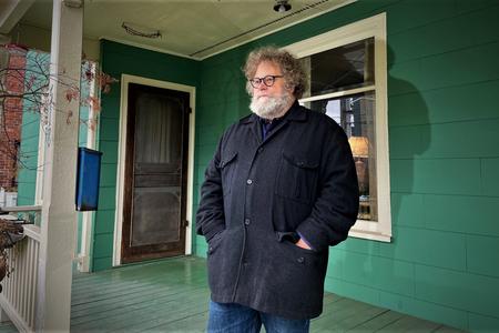 Host Knute Berger stands on a porch