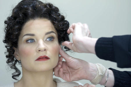 Pair of hand pins a wig on a woman