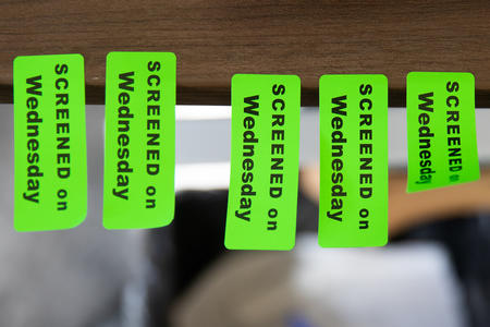 Stickers signifying patients and staff have been screened