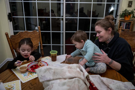 A mother and her children at the kitchen table