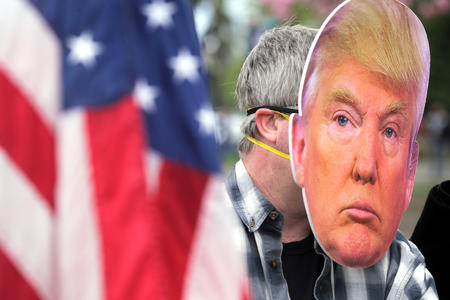 Man at a rally in a trump mask