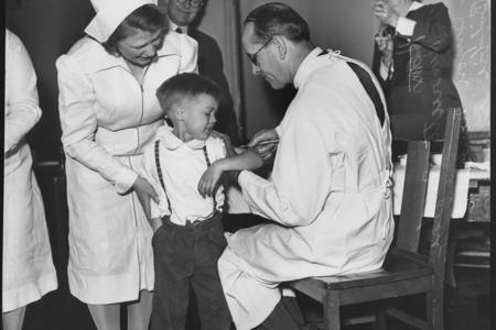 Boy gets vaccine from doctor