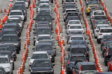 Lines of cars wait at a drive-through coronavirus testing site
