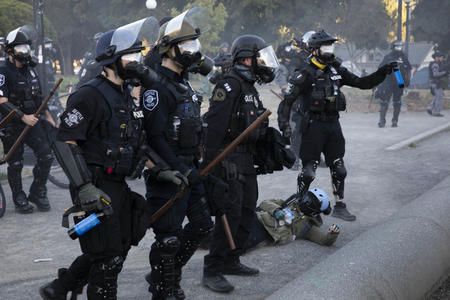 Four Seattle police officers wearing gas masks on a street