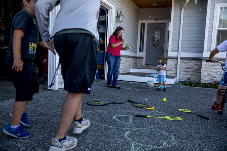 Children and an adult playing in a driveway
