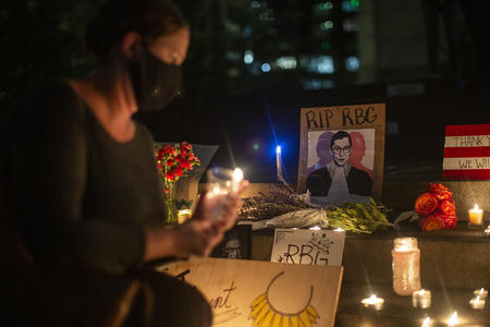 a mourner infront of an image of RGB