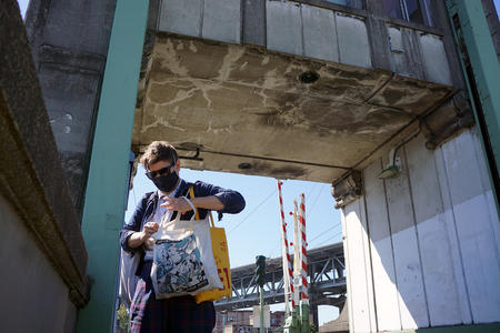 E.T. Russian looks through bag while under the bridge tower outside
