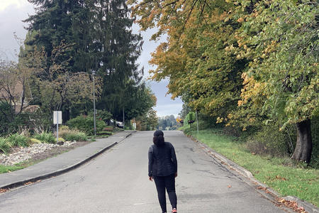 woman walking on street in fall foliage