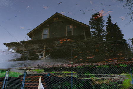 A house seen in the reflection of a puddle