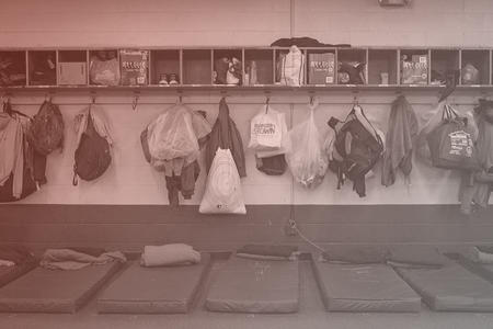 mats and bags lined up at a homeless shelter