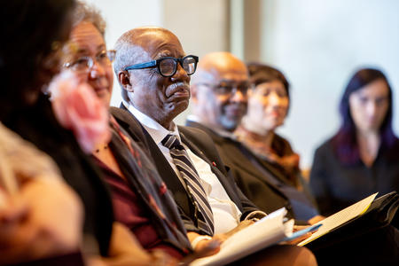 James A. Banks seated in a row of people
