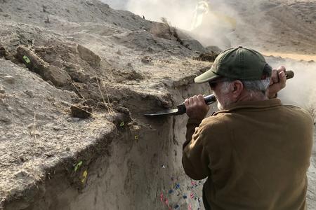 A geologist digs at a fault line