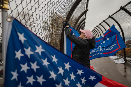 Woman hanging signs and flags in support of Donald Trump