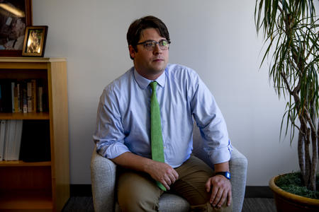 Man in tie seated in chair