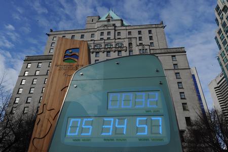 A sign with numbers in front of a tall building.
