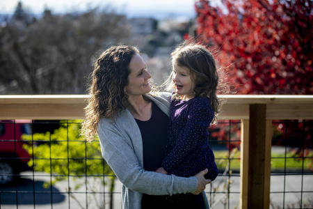 A mother holds her daughter outside