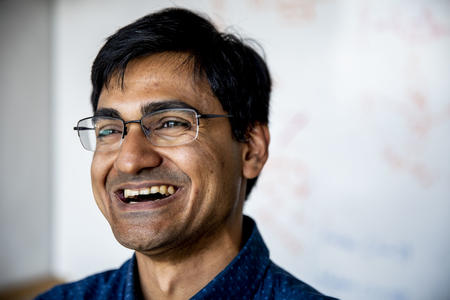 man laughing in front of white board