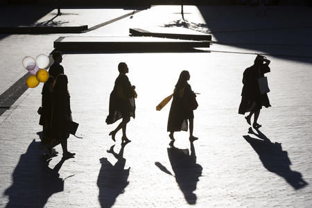 A group of graduates in silhouette walk through Red Square