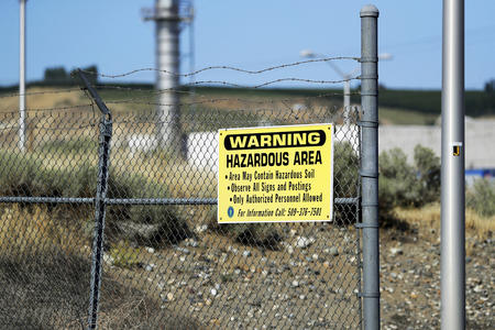 A warning sign on a chain-link fence